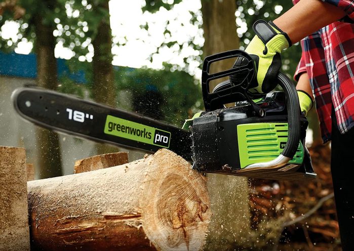 Cutting wood logs using chainsaw